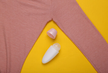 Antiperspirant stick and sweater on a yellow background. Sweat and stain resistant