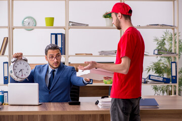 Young man delivering pizza to the office in time management conc