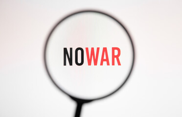 Inscription nowar on white screen of the monitor through magnifying glass