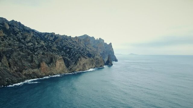 Aerial view from the sea to the rocks and coastline of the extinct volcano Karadag.