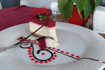 Cheesecake on a white plate. artistic cheesecake with raspberries and chocolate