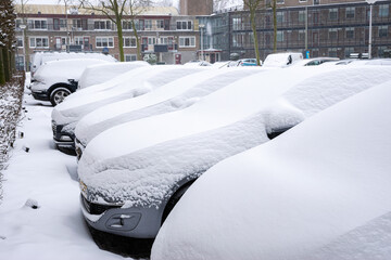 Cars are covered with a thick layer of fresh snow