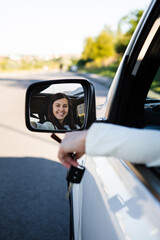 pretty woman sitting in car and showing keys