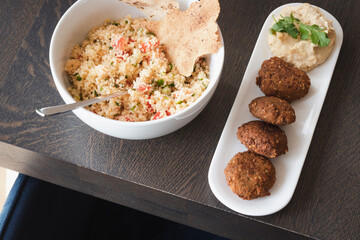 Home cooked arabian food plate, hummus with falafel, couscous and red cabbage