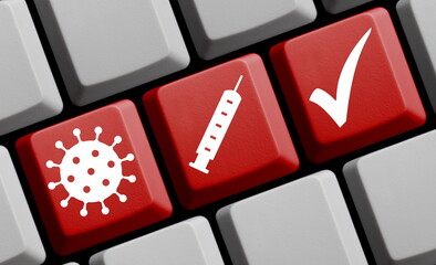Coronavirus Symbol und Spritze auf roter Computer Tastatur