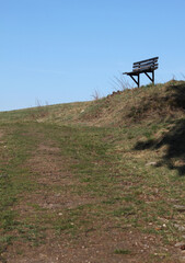 abandoned bench on the horizon on a hill in the spring landscape