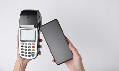 Contactless payment. Hand with smartphone pays payment terminal on white background