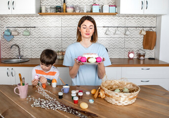  Young beautiful woman and her cute son preparing for Easter in the kitchen