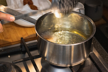 Frying chicken nuggets in oil on a frying pan