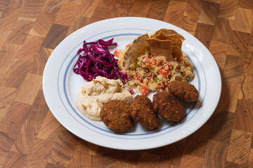 Home cooked arabian food plate, hummus with falafel, couscous and red cabbage