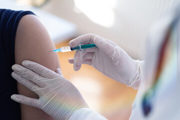 Covid vacine injection by doctor at hospital.Doctor making injection vaccination patient to prevent...
