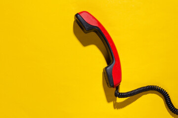 Retro cable phone tube on yellow bright background. Copy space