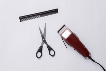 Machine for haircuts, scissors and comb on white background. Barbershop. Hair clipper. Top view. Flat lay