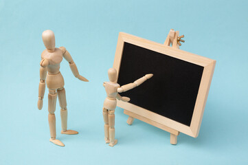 Mini chalk board and wooden puppets on blue background. Learning, business, education, school...