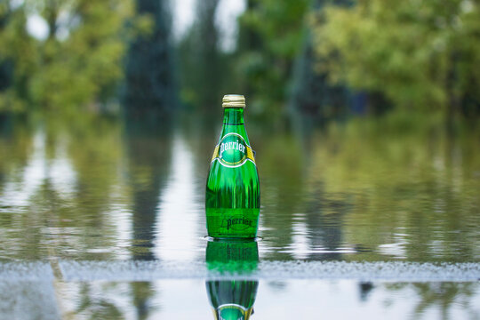 KRASNODAR, RUSSIA - September 26, 2020: A bottle of perrier mineral water on the water surface in Krasnodar park. Perrier is a French brand of natural bottled mineral water