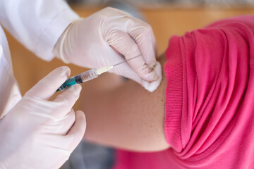 Covid vacine injection by doctor at hospital.Doctor making injection vaccination patient to prevent pandemic of the disease, flu or influenza virus in clinic