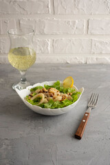 warm seafood salad with green lettuce leaves with young white wine
