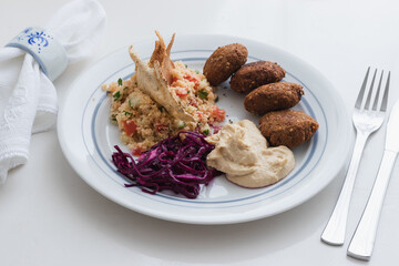 Home cooked arabian food plate, hummus with falafel, couscous and red cabbage