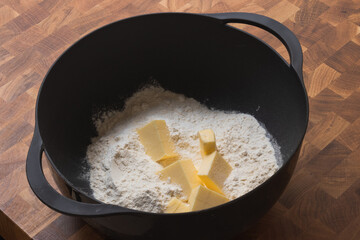 Flour with butter inside a black bowl 