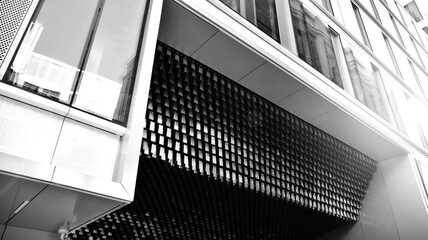 Downtown corporate business district architecture. Glass reflective office buildings against  sky. Economy, finances, business activity concept. Rising sun on the horizon. Black and white.