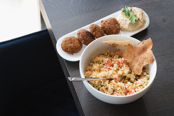Home cooked arabian food plate, hummus with falafel, couscous and red cabbage