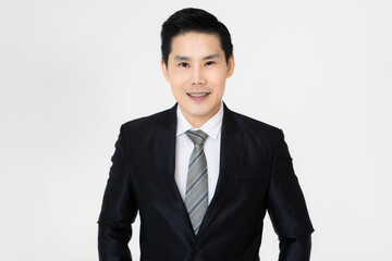 Young and handsome black hair Asian businessman in dark tone suit standing and looking to camera, pose with self-confidence and trust