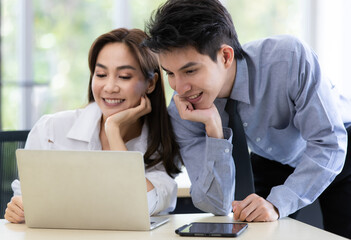 Beautiful black long hair Asian businesswoman and gook looking cute Asian businessman working together in office with intimate gesture and teamwork pose