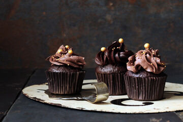 Schokoladencupcake mit Schokoladenfrosting und goldenen Zuckerperlen