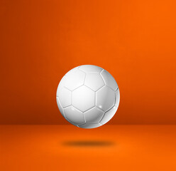 White soccer ball on a orange studio background