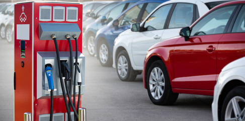 Electric vehicles charging station on a background of a row of cars. Concept	