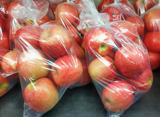 Fresh organic apples are packed in plastic bags, Red apples ready to be sold in supermarkets. - 417105569