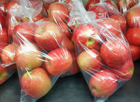 Fresh organic apples are packed in plastic bags, Red apples ready to be sold in supermarkets.
