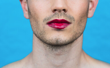 close-up detail of a trans man with lipstick on a blue background