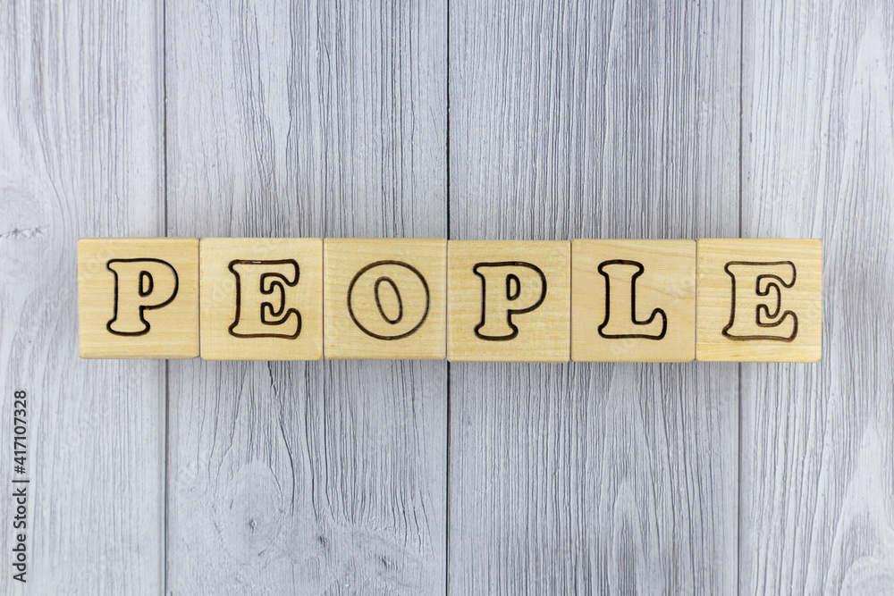 Fototapete natural wooden blocks with the letters and word - people - arranged to the centre on a background of