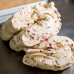 Raw light dough with cranberries. Red berries in raw dough. Bakery concept