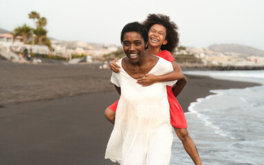 Happy African family on the beach during summer holidays - Afro American people having fun on...