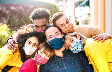 Multicultural milenial friends taking selfie smiling behind face masks - New normal friendship and...