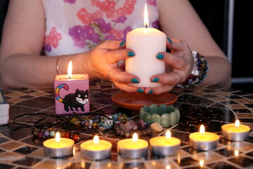 Fortune telling session, seeing the destiny and astrology. Female hands with candles on the round...