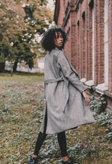 African american model woman posing near brick building