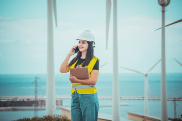 adult female engineer supervises solar panels and windmills in a renewable energy complex