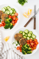 Vegetarian dish of potato patties with herbs and vegetables in a plate
