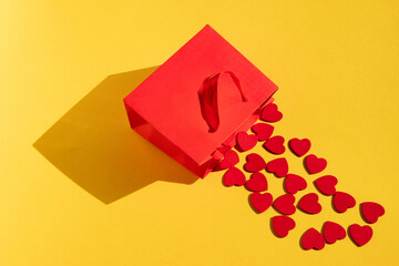 Small hearts are falling out of a red decorative bag. Creative idea for March 8th.