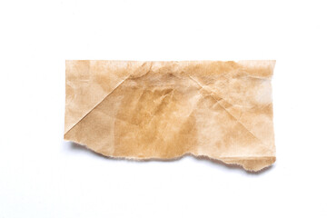 close up of a ripped piece of brown spaper on white background