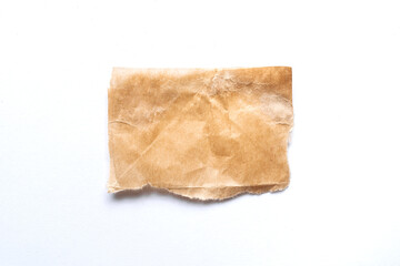 close up of a ripped piece of brown spaper on white background