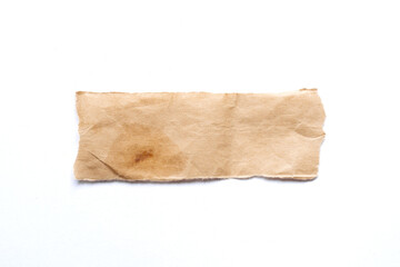 close up of a ripped piece of brown spaper on white background