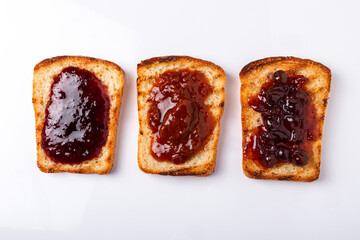 slices of bread with different kinds of jam spread on them on a white background top view