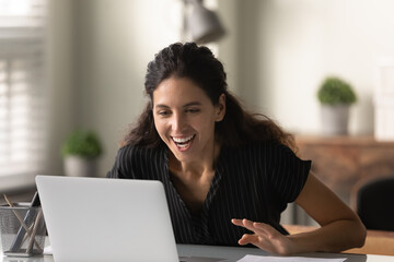 Close up surprised overjoyed woman looking at laptop screen, reading good news in message,...