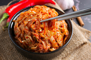 Korean food, Cabbage kimchi in black dish set on dark background.