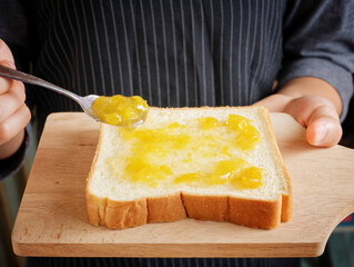 Red strawberry and peach yellow jam on plank wood and slice bread.