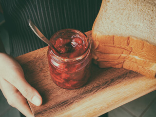 Red strawberry and peach yellow jam on plank wood and slice bread.